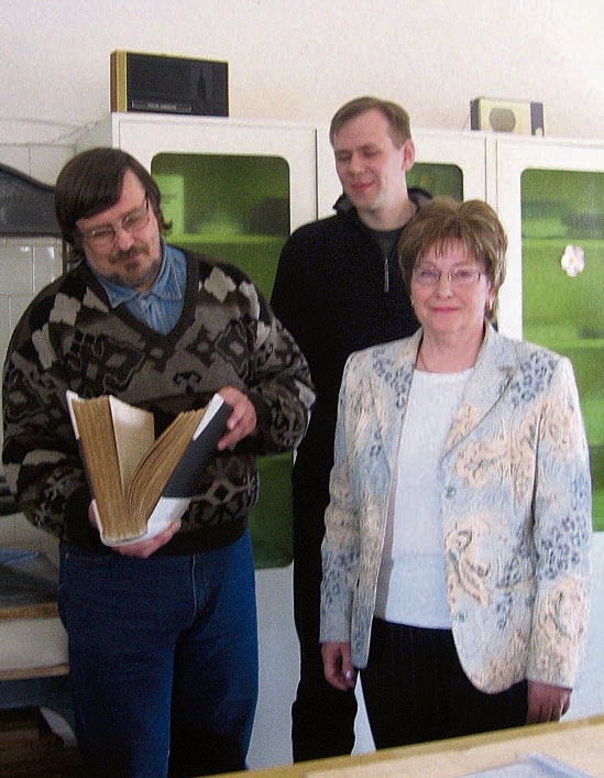 Restaureeritud Kodavere kirikuraamat, koguduse õpetaja Raigo Ojamets (vasakul), arhivaar Janis Tobreluts ja Mandragora juhataja Ene Sarap.