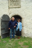 Koguduse juhatuse esimees Tõnu Grepp ja kirikuvalvur Regina Vihuri. Nende peade kohal paistab kiriku lõunaportaali ehtiv Kolgata reljeef. Fotod: Rita Puidet