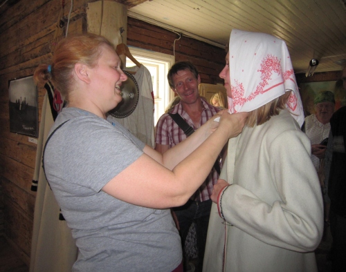 Kauksi Ülle sätib seto naise riietesse tallinlannat Marelle Sillandit. Elevusega jälgib toimingut giid Ervin Org. Kauksi Ülle sätib seto naise riietesse tallinlannat Marelle Sillandit. Elevusega jälgib toimingut giid Ervin Org.