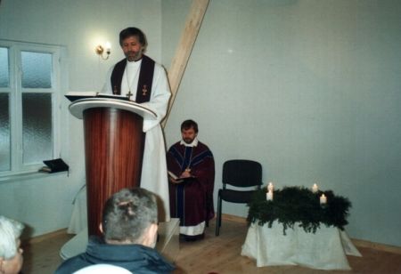 Girts Kalninš tervitamas uuest kantslist, tagaplaanil istub peapiiskop Jānis Vanags. Arvo Lasting