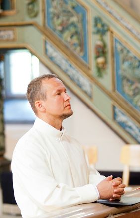 Kalle Kõiv kinnitab diakonitõotust altari ees põlvitades.  Krista Kõiv